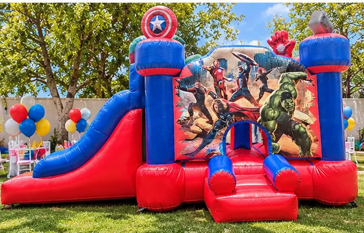 Inflable de Avengers con resbaladilla roja y azul en un jardín