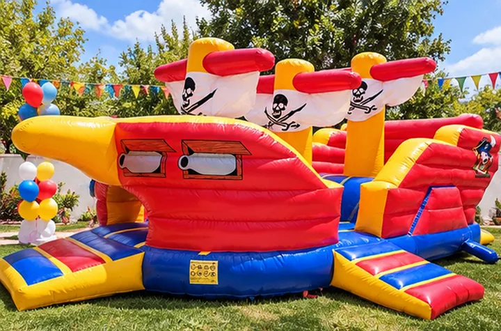 Inflable barco pirata armado en un jardín con globos de colores