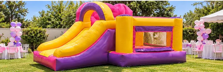 Inflable de princesas con resbaladilla amarilla y rosa en un jardín